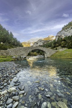 The Bujaruelo Bridge is a 13th century Romanesque bridge over the Ara River, in the province of Huesca, in the Aragonese Pyrenees. clipart