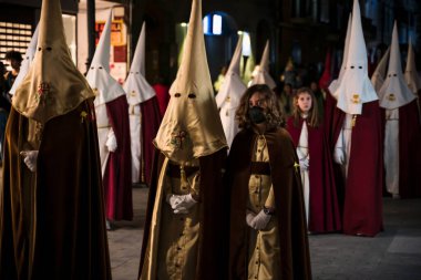 Gandia, İspanya - 16 Nisan 2022: Kapüşonlu insanlar ve kızlarla Paskalya Geçidi