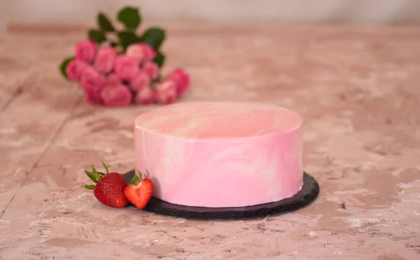 Strawberry mousse cake covered with mirror glaze and fresh strawberries