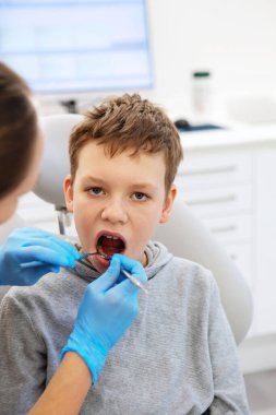 Kid in a dental clinic. Orthodontic treatment. Children's dentistry, Pediatric Dentistry. A boy in braces on his teeth at a dentist's appointment. Oral health and hygiene. 