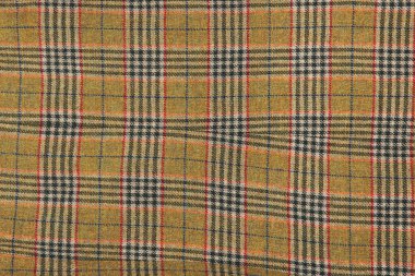 Yün ekose kumaş. Yumuşak ve sıcak katlanmış alpaka yün battaniyesi. Yeşil ve turuncu yün ekose desenli makro shot. Yün ceket