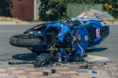 Motosiklet bir trafik kazasından sonra kaldırımda yatıyor. Hasarlı motosiklet asfalt yolda duruyordu. Ciddi bir kaza. DNIPRO, UKRAINE 6 Temmuz 2020