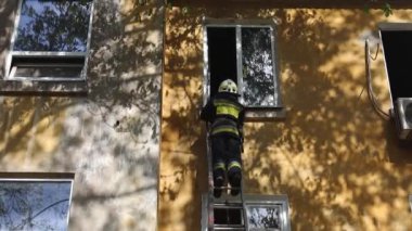 Koruyucu üniformalı cesur bir itfaiyecinin görüntüsü. Koruyucu ekipmanlı bir kurtarıcı. İtfaiyeciler yerleşim yerindeki yangını söndürdüler. DNIPRO, UKRAINE 30 Nisan 2021