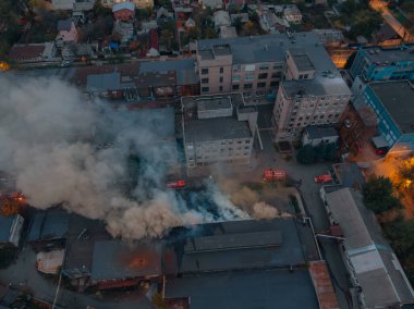 Yanan bir endüstriyel binanın havadan görüntüsü. Gece yangını. Duman gökyüzünde Depoda güçlü ateş.