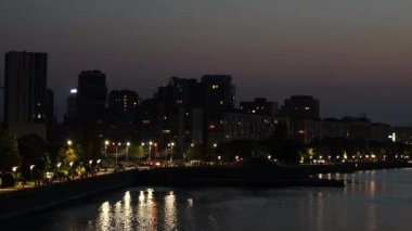 Kulelerin gece panoramik görüntüsü, Ukrayna 'daki Dinyeper Nehri yakınlarındaki gökdelenler. Dnipro şehri. Büyük, güzel bir şehirde sakin bir nehir Dinyeper 'ı. Gerçek zamanlı UHD 4K videosu