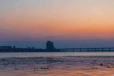 Gün batımında ya da gün doğumunda Dnipro şehrinin panoramik görüntüsü. Dnipro Nehri 'nde muhteşem bir gün batımı ve tarihi merkez manzarası. Sıcak günler. arkaplan resmi. Ukrayna şehri.