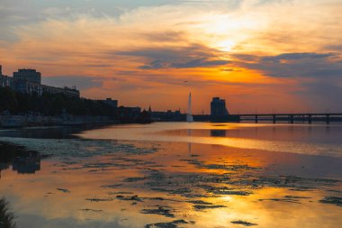 Gün batımında ya da gün doğumunda Dnipro şehrinin panoramik görüntüsü. Dnipro Nehri 'nde muhteşem bir gün batımı ve tarihi merkez manzarası. Sıcak günler. arkaplan resmi. Ukrayna şehri.