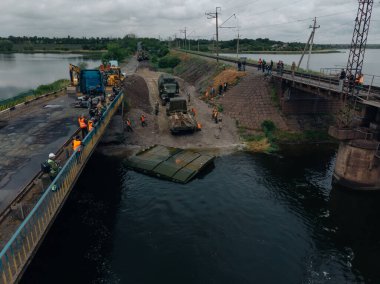 Ukrayna ordusunun Pontoon köprüsü. Yok edilen köprünün yakınına geçici bir geçit kurulmuş. Askerler duba feribotu topluyor. İHA 'nın üst görüntüsü. Nikopol, UKRAINE 26 Mayıs 2020