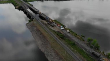 Ukrayna ordusunun Pontoon köprüsü. Yok edilen köprünün yakınına geçici bir geçit kurulmuş. Askerler duba feribotu topluyor. Bir İHA 'dan üst görünüm. 