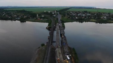 Ukrayna ordusunun Pontoon köprüsü. Yok edilen köprünün yakınına geçici bir geçit kurulmuş. Askerler duba feribotu topluyor. Bir İHA 'dan üst görünüm. 