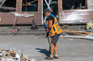 Rus grevinin sonuçları. Dnepr şehrinde, otobüs durağının binasına bir roket çarptı. Kamu hizmetleri çalışanları çarpışmanın sonuçlarını ortadan kaldırıyor. DNIPRO, UKRAINE Ağustos 2023