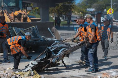 Rus grevinin sonuçları. Dnepr şehrinde, otobüs durağının binasına bir roket çarptı. Kamu hizmetleri çalışanları çarpışmanın sonuçlarını ortadan kaldırıyor. DNIPRO, UKRAINE Ağustos 2023