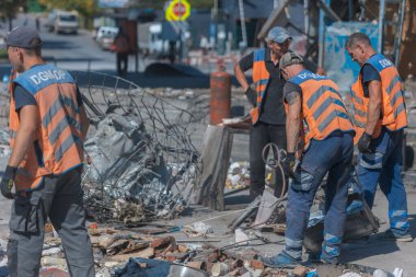 Rus grevinin sonuçları. Dnepr şehrinde, otobüs durağının binasına bir roket çarptı. Kamu hizmetleri çalışanları çarpışmanın sonuçlarını ortadan kaldırıyor. DNIPRO, UKRAINE Ağustos 2023