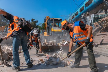 Rus grevinin sonuçları. Dnepr şehrinde, otobüs durağının binasına bir roket çarptı. Kamu hizmetleri çalışanları çarpışmanın sonuçlarını ortadan kaldırıyor. DNIPRO, UKRAINE Ağustos 2023