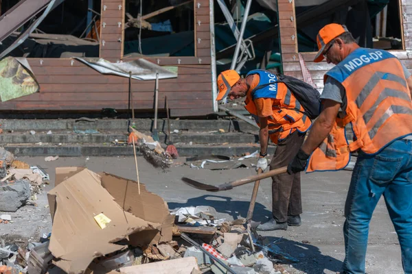 Rus grevinin sonuçları. Dnepr şehrinde, otobüs durağının binasına bir roket çarptı. Kamu hizmetleri çalışanları çarpışmanın sonuçlarını ortadan kaldırıyor. DNIPRO, UKRAINE Ağustos 2023