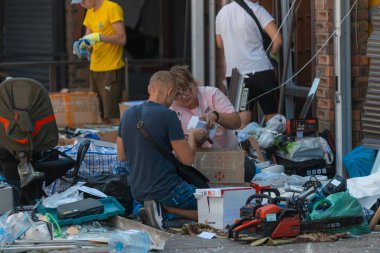 Ukrayna halkı otobüs durağındaki roket saldırısının kurbanlarına yardım etmek için toplandı. Mahvolmuş tezgahlar, perakende satış yerleri. Kırık camlar, hasarlı eşyalar. - İnsanlar. DNIPRO, UKRAINE 24 Ağustos 2023