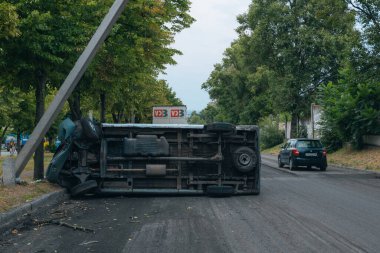 Araba bir sokak lambasına çarptı ve yan yattı. Araba bir tarafta kaldı. Yoldaki kırık ön cam trafik kazaları. DNIPRO, UKRAINE - 12 Ağustos 2023