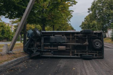 Araba bir sokak lambasına çarptı ve yan yattı. Araba bir tarafta kaldı. Yoldaki kırık ön cam trafik kazaları. DNIPRO, UKRAINE - 12 Ağustos 2023