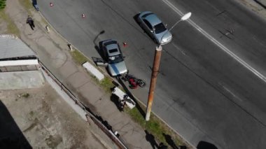 Motosiklet bir geziden sonra kaldırımda yatar. Ciddi bir kaza. Bir araba bir motosikletliye çarptı.