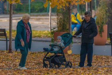 İnsanlar sonbahar parkında ve meydanda yürüyor. Hayattaki mutlu anlar. Ukraynalı erkek ve kızlar Dnipro şehrinde dolaşıyorlar. DNIPRO, UKRAINE Ekim 2023