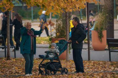 İnsanlar sonbahar parkında ve meydanda yürüyor. Hayattaki mutlu anlar. Ukraynalı erkek ve kızlar Dnipro şehrinde dolaşıyorlar. DNIPRO, UKRAINE Ekim 2023