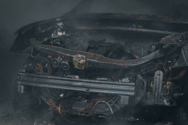 İtfaiyeciler yanan bir arabayı garajda söndürür. Yanmış araba. Kurtarıcılar. Sağlam duman. Acil durum. Sigorta davası.