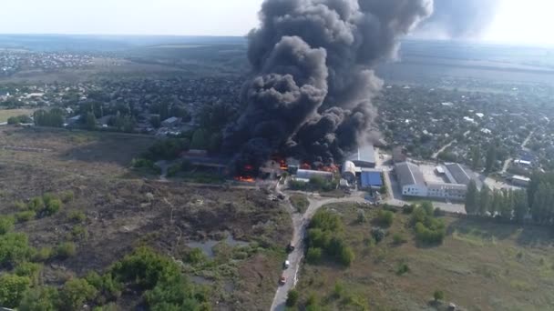 ロケットが工場を襲った 倉庫に強い火を建てている倉庫 黒い煙と火 大規模な火災でドローンから撮影 グレイン ビデオ 救助隊は大きな火を放った — ストック動画
