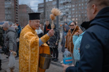 Hristiyan bayramı. Tatil boyunca rahip, Ortodoks azizlerinin üzerine kutsal su serper. Dini ayin. Din. DNIPRO, UKRAINE 6 Ocak 2024