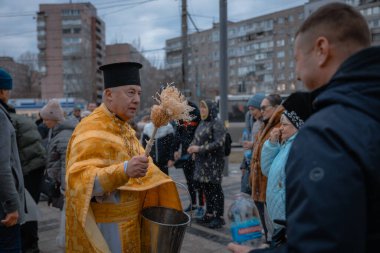 Hristiyan bayramı. Tatil boyunca rahip, Ortodoks azizlerinin üzerine kutsal su serper. Dini ayin. Din. DNIPRO, UKRAINE 6 Ocak 2024