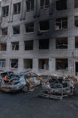 Shahed evleri havaya uçurdu. Saldırıdan sonra bombalanmış bir bina ve yanmış arabalar. Ukrayna 'da savaş, Dnipro şehri. Yanmış araba..