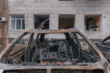 Shahed evleri havaya uçurdu. Saldırıdan sonra bombalanmış bir bina ve yanmış arabalar. Ukrayna 'da savaş, Dnipro şehri. Yanmış araba..
