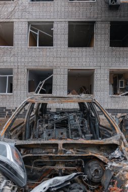 Shahed evleri havaya uçurdu. Saldırıdan sonra bombalanmış bir bina ve yanmış arabalar. Ukrayna 'da savaş, Dnipro şehri. Yanmış araba..