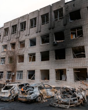 Shahed evleri havaya uçurdu. Saldırıdan sonra bombalanmış bir bina ve yanmış arabalar. Ukrayna 'da savaş, Dnipro şehri. Yanmış araba..