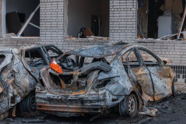 Shahed evleri havaya uçurdu. Saldırıdan sonra bombalanmış bir bina ve yanmış arabalar. Ukrayna 'da savaş, Dnipro şehri. Yanmış araba..