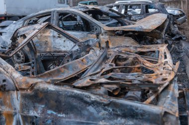 Shahed evleri havaya uçurdu. Saldırıdan sonra bombalanmış bir bina ve yanmış arabalar. Ukrayna 'da savaş, Dnipro şehri. Yanmış araba..