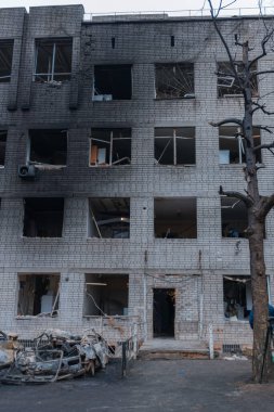 Shahed evleri havaya uçurdu. Saldırıdan sonra bombalanmış bir bina ve yanmış arabalar. Ukrayna 'da savaş, Dnipro şehri. Yanmış araba..