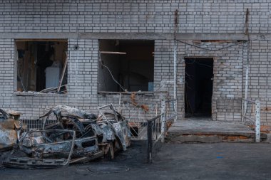 Shahed evleri havaya uçurdu. Saldırıdan sonra bombalanmış bir bina ve yanmış arabalar. Ukrayna 'da savaş, Dnipro şehri. Yanmış araba..