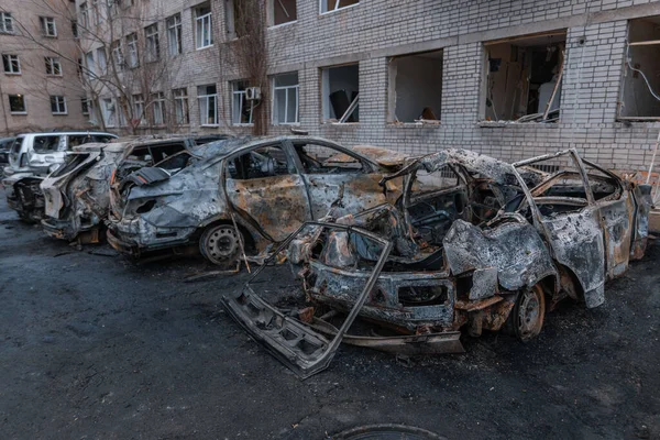 Shahed evleri havaya uçurdu. Saldırıdan sonra bombalanmış bir bina ve yanmış arabalar. Ukrayna 'da savaş, Dnipro şehri. Yanmış araba..