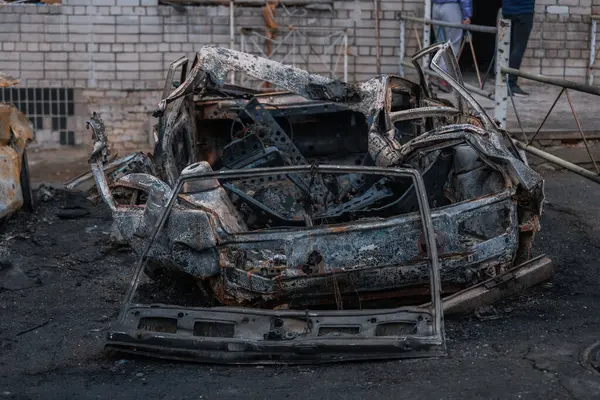 Shahed evleri havaya uçurdu. Saldırıdan sonra bombalanmış bir bina ve yanmış arabalar. Ukrayna 'da savaş, Dnipro şehri. Yanmış araba..