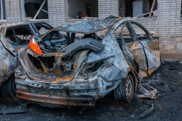 Shahed evleri havaya uçurdu. Saldırıdan sonra bombalanmış bir bina ve yanmış arabalar. Ukrayna 'da savaş, Dnipro şehri. Yanmış araba..