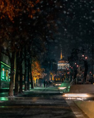 Kış gecesi manzarası. Arkaplanı bulanıklaştır. Şehir akşam karı. Soğuk hava. İnsanlar şehirde dolaşıyor. Resimli bir manzara. Savaş sırasında Ukrayna şehri. DNIPRO, UKRAINE 3 Ocak 2024