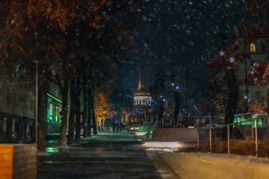 Kış gecesi manzarası. Arkaplanı bulanıklaştır. Şehir akşam karı. Soğuk hava. İnsanlar şehirde dolaşıyor. Resimli bir manzara. Savaş sırasında Ukrayna şehri. DNIPRO, UKRAINE 3 Ocak 2024