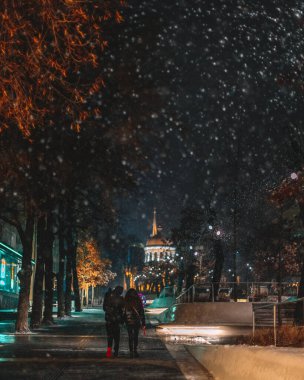 Kış gecesi manzarası. Arkaplanı bulanıklaştır. Şehir akşam karı. Soğuk hava. İnsanlar şehirde dolaşıyor. Resimli bir manzara. Savaş sırasında Ukrayna şehri. DNIPRO, UKRAINE 3 Ocak 2024