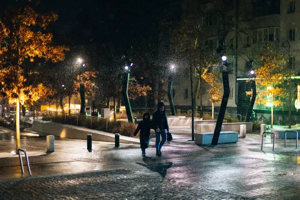 Kış gecesi manzarası. Arkaplanı bulanıklaştır. Şehir akşam karı. Soğuk hava. İnsanlar şehirde dolaşıyor. Resimli bir manzara. Savaş sırasında Ukrayna şehri. DNIPRO, UKRAINE 3 Ocak 2024