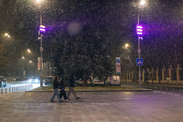 Kış gecesi manzarası. Arkaplanı bulanıklaştır. Şehir akşam karı. Soğuk hava. İnsanlar şehirde dolaşıyor. Resimli bir manzara. Savaş sırasında Ukrayna şehri. DNIPRO, UKRAINE 3 Ocak 2024