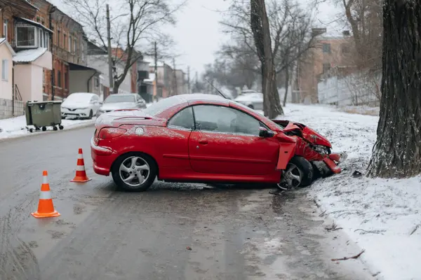 Araba bir trafik kazasında tahrip edildi. Araba terk edilmiş ve karda yolun kenarında duruyor. Kontrolünü kaybetti ve bir ağaca çarptı. DNIPRO, UKRAINE 25 Ocak 2024