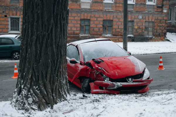 Araba bir trafik kazasında tahrip edildi. Araba terk edilmiş ve karda yolun kenarında duruyor. Kontrolünü kaybetti ve bir ağaca çarptı. DNIPRO, UKRAINE 25 Ocak 2024