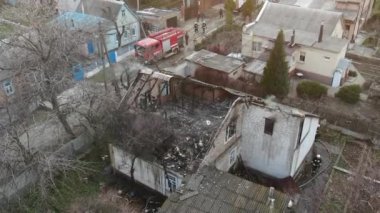 Yanmış bir evin üst manzarası. Ev tamamen yangın tarafından tahrip edildi. Çatı çöktü, duvarlar siyaha döndü. Yanmış eşyalar evin etrafına saçılmış. Özel bir evde yangın.