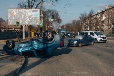 Bir şehir caddesinde iki arabanın karıştığı bir kaza meydana geldi. Hasarlı arabalar. Ciddi bir kaza. Arabalardan biri devrilmiş..