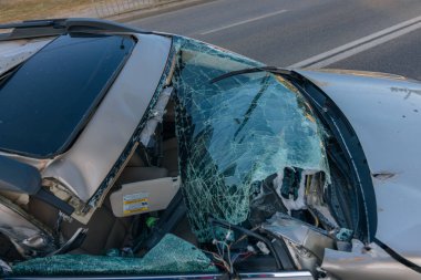 Otoyolda bir araba çarpıştı. Ciddi bir kaza. Yoldaki trafik kazaları. Kırık ön cam. Araba bir kamyonun karavanının altında uçtu. Trafik sıkışık. Sigorta davası yolda.